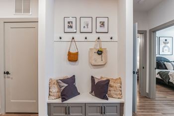 A bedroom with a bench with pillows and bags on it